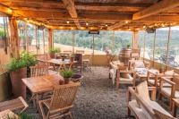 un ristorante con tavoli e sedie in legno e finestre di Casa Blu litorale Andora a Marina dʼAndora