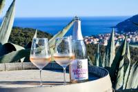 due bicchieri di vino bianco accanto a una bottiglia di Casa Blu litorale Andora a Marina dʼAndora