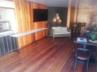 uma sala de estar com piso em madeira e uma televisão em The Tamek Palace Hotel em Palapye