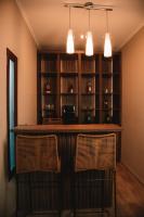 Un bar en una habitación con dos sillas y un estante. en Catriel Suites, en Catriel