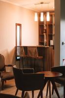 Una sala de espera con sillas y mesas y un mostrador. en Catriel Suites, en Catriel