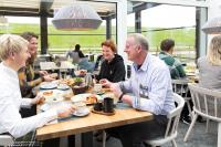 Un grupo de personas sentadas en una mesa comiendo comida en Hotel Regina Maris, en Norddeich