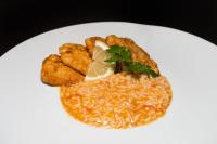 a plate of food with rice and fish and a garnishment at Alva Valley Hotel in Oliveira do Hospital