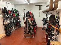 a room with a bunch of skis and snowboards at Sporthotel Igls in Innsbruck