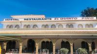 un bâtiment avec une enseigne au sommet dans l'établissement Hostal Quinto Pino, à Chipiona