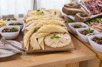 een tafel met kaas en andere voedingsmiddelen op tafel bij Perdepera Resort in Cardedu