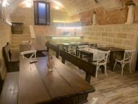 Un restaurante con mesas y sillas de madera en una sala. en Palazzo Mellacqua, en Andrano