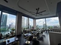 een restaurant met tafels en stoelen en grote ramen bij Star Suite 5min Walk to KLCC Netflix in Kuala Lumpur