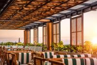 eine Reihe von Stühlen und Tischen auf einer Terrasse in der Unterkunft Cross Paasha Bali Seminyak in Seminyak