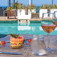 um prato de comida e um copo de vinho ao lado de uma piscina em La Tour Blanche em Gammarth