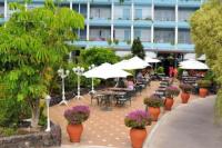 Ankerplatz - casa Juseli - Ruhe und Erholung في سانتا أورسولا: فناء به طاولات وكراسي ومظلات وزهور