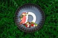 uma letra g em um prato de papel com frutas e vegetais em Seegut Zeppelin em Friedrichshafen