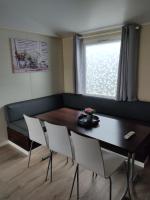 a dining room with a table and chairs and a window at Camping du phare d opale p48 in Le Portel