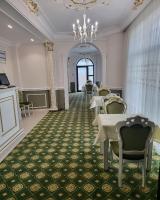 een eetkamer met tafels en stoelen en een kroonluchter bij Regal Beius in Beiuş