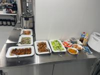 un mostrador con varias bandejas de comida. en ５８ビレッジ種子島, en Ishidera