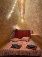 a bedroom with a bed with two pillows on it at Tiny House et yourte sous les Poiriers in Domfront