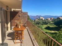 a table and chairs on a balcony with a view at Piana - vue mer et village in Piana