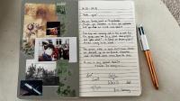 a page of a notebook with a pen and photographs at L&#39;Escapade de Pierrefonds par Your Sweet Loc in Pierrefonds