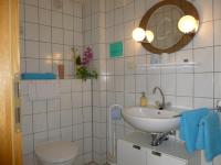 a bathroom with a sink and a toilet and a mirror at Pension am Peeneufer UG in Wolgast