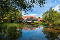 una casa en un río con un barco delante en Chevin Country Park Hotel &amp; Spa, en Otley