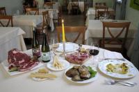 a table with plates of food and bottles of wine at Il Rampicante-Monticelli Terme in Monticelli Terme