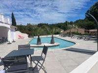 a pool with chairs and a table and a table and chairs at Les Vergers in Gonfaron