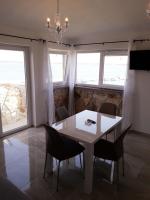 ein Esszimmer mit einem weißen Tisch und Stühlen in der Unterkunft Moderne Wohnung in Privlaka mit Terrasse, Garten und Grill in Privlaka