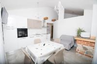eine Küche und ein Esszimmer mit einem weißen Tisch und Stühlen in der Unterkunft Moderne Wohnung in Privlaka mit Terrasse, Garten und Grill in Privlaka