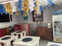 a restaurant with two tables and a refrigerator at Sugarland Hotel and Suite GRA Ikeja Lagos in Lagos