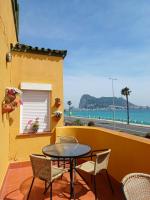 Una mesa y sillas en un balcón con vista al mar. en Gibraltar Views Guest House, en La Línea de la Concepción