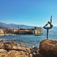 Una estatua de una mujer parada en una roca cerca del agua en Bobo Apartment, en Budva
