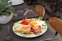 a plate of food with eggs bread and vegetables on a table at Central Sapa Serenity Homestay in Sa Pa