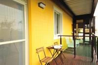 a yellow house with chairs and a table on a porch at Little Sunshine in Dongshan