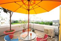 a table and chairs on a balcony with an umbrella at Little Sunshine in Dongshan