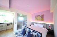 a bedroom with pink and purple walls and a bed with blue pillows at Little Sunshine in Dongshan