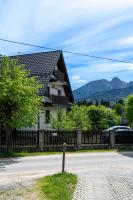 a house with a fence next to a road at Willa Serafin-basen, sauny i jacuzzi w Willa Baciarka dodatkowo płatne in Kościelisko
