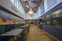a dining room with tables and chairs and paintings on the walls at CHATEAU R in Wettolsheim