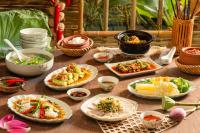 a table with plates of food and bowls of food at HAIAN Riverfront Hotel Da Nang in Da Nang