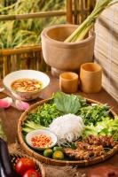 a table topped with a plate of food with vegetables at HAIAN Riverfront Hotel Da Nang in Da Nang