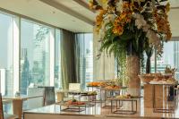 a buffet line with food on tables in a room with windows at Eastin Grand Hotel Sathorn in Bangkok