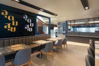 ein Restaurant mit Tischen und Stühlen und eine Bar in der Unterkunft Lumen Bangkok Udomsuk Station in Bangkok