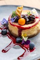 a dessert on a plate with blueberries and sauce at Hotel Alexandrion Experience in Sinaia