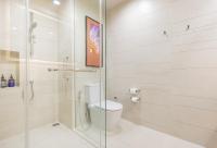 a white bathroom with a toilet and a shower at Eastin Grand Hotel Sathorn in Bangkok
