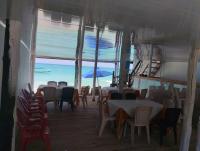 Um restaurante com mesas e cadeiras e vista para o oceano. em HOSTAL LAMAR BARU dónde Gertrudis em Playa Blanca