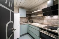 a kitchen with blue cabinets and wooden walls at WIROtel Warnemünde in Warnemünde