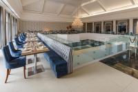 a restaurant with a long glass counter and blue chairs at Blue Tree Daj Resort & Marina in Ribeirão Claro