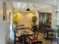 a restaurant with tables and chairs in a room at Au Relais Gascon in Labastide-dʼArmagnac