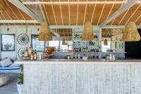 une cuisine avec un bar et deux luminaires suspendus dans l'établissement Escape to Paradise, Deluxe Fractional 2BR Garden Pool Villa Private Beach Near Uluwatu, à Uluwatu