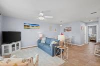 ein Wohnzimmer mit einem blauen Sofa und einem Fernseher in der Unterkunft Condo in Gulf Shores King Suite in Gulf Shores