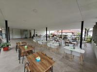 ボゴールにあるHOTEL & WISMA BINTANG JADAYATの木製のテーブルと椅子が置かれた空のレストラン